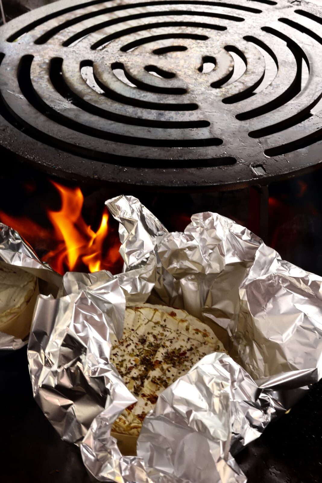 Camembert aux herbes en papillote près des flammes du foyer